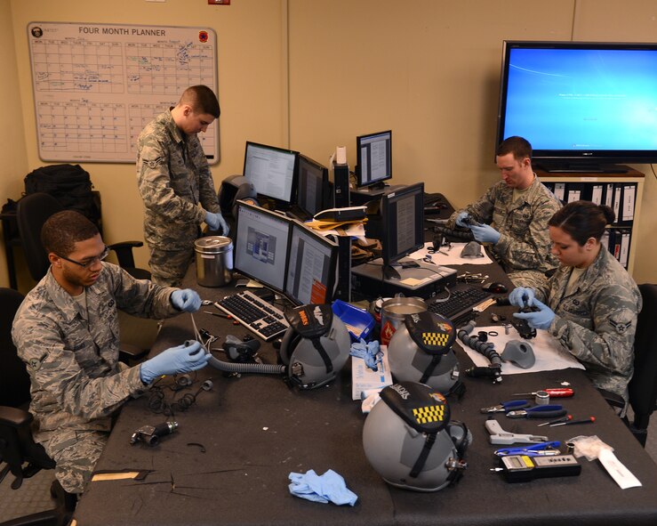 Airmen from the 2nd Operations Support Squadron Aircrew Flight Equipment helmet section inspect, assemble and disassemble helmets on Barksdale Air Force Base, La., Aug. 4, 2014. AFE Airmen provide aircrew with the proper lifesaving equipment used in the event of a crash including helmets, oxygen masks, survival vests, anti-exposure suits, life preservers and night vision goggles. (U.S. Air Force photo/Senior Airman Benjamin Gonsier)