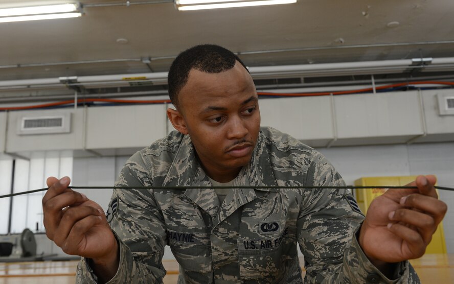 Senior Airman Jereme Haynie, 2nd Operations Support Squadron Aircrew Flight Equipment parachute section, inspects a 550 cord on Barksdale Air Force Base, La., Aug. 4, 2014. When inspecting the cords, AFE Airmen look for tears, indicated by white marks, and other signs of damage. (U.S. Air Force photo/Senior Airman Benjamin Gonsier)