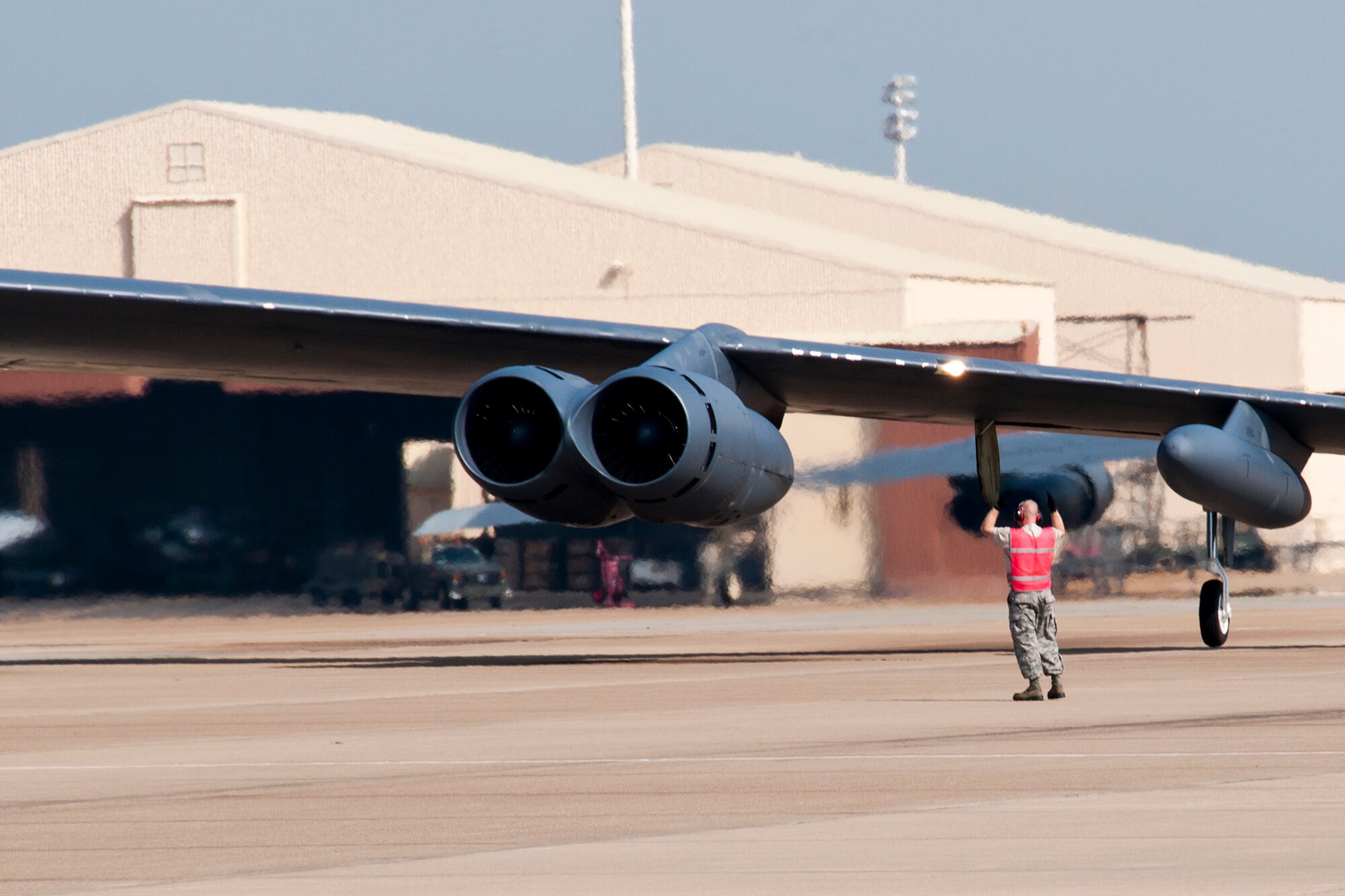 U.S. Air Force Tech. Sgt. Jessie Brouillette, 307th Aircraft Maintenance Squadron crewchief, marshals a 93rd Bomb Squadron (BS) B-52H Stratofortress from its parking spot before taking off for a mission on Aug. 3, 2014, Barksdale Air Force Base, La. The 93rd BS is a Formal Training Unit that trains all Active Duty and Reserve aircrew to fly the B-52. (U.S. Air Force photo by Tech. Sgt. Ted Daigle/Released)