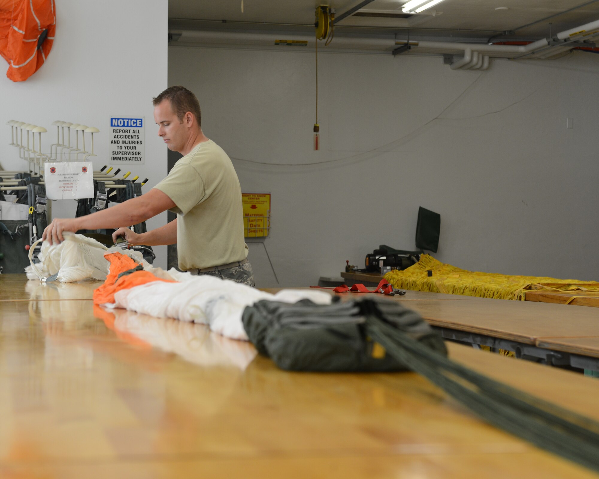 Staff Sgt. Cody Markham, 2nd Operations Support Squadron Aircrew Flight Equipment parachute section, inspects a C-9 canopy on Barksdale Air Force Base, La., Aug. 4, 2014. The parachute section inspects every string, stitch and mechanism used to keep the parachutes serviceable. (U.S. Air Force photo/Senior Airman Benjamin Gonsier)