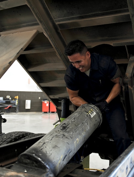 U.S. Air Force Airman 1st Class Jorge Diehl, 7th Logistics Readiness Squadron vehicle maintenance apprentice, installs a hydraulic cylinder in a dump truck Aug. 5, 2014, at Dyess Air Force Base, Texas. The hydraulic cylinder is used to actuate the bed of the truck. (U.S. Air Force photo by Airman 1st Class Kedesha Pennant/Released)