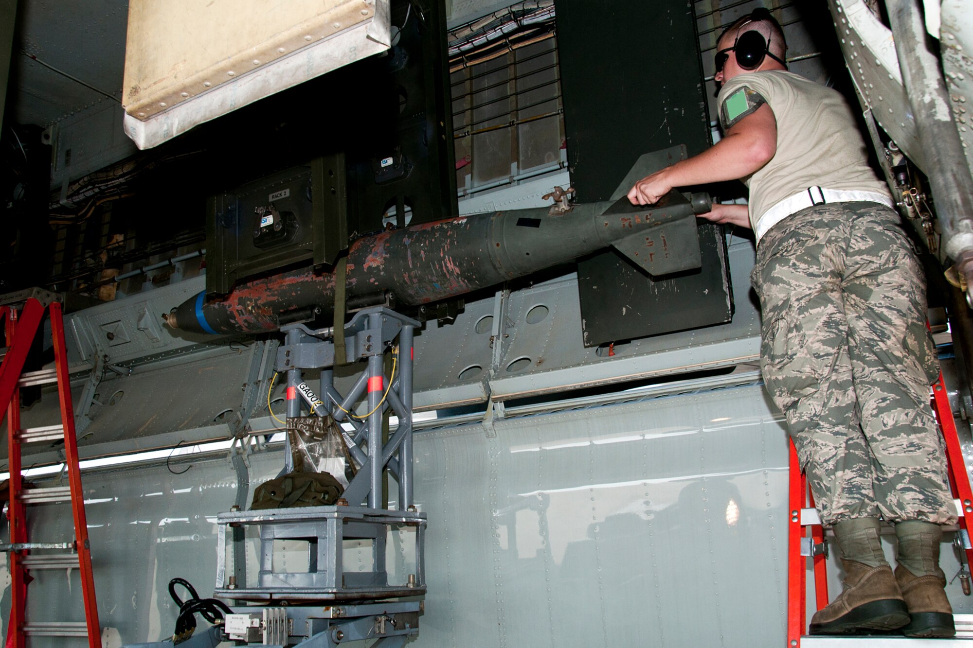 U.S. Air Force Senior Airman Riley St. John guides an inert 500 pound general purpose bomb into the bomb bay of a B-52H Stratofortress during weapons load crew training on Aug. 3, 2014, Barksdale Air Force Base, La. Crews are required to participate in the training to acquire or maintain certification for loading live munitions on the aircraft. (U.S. Air Force photo by Tech. Sgt. Ted Daigle/Released)