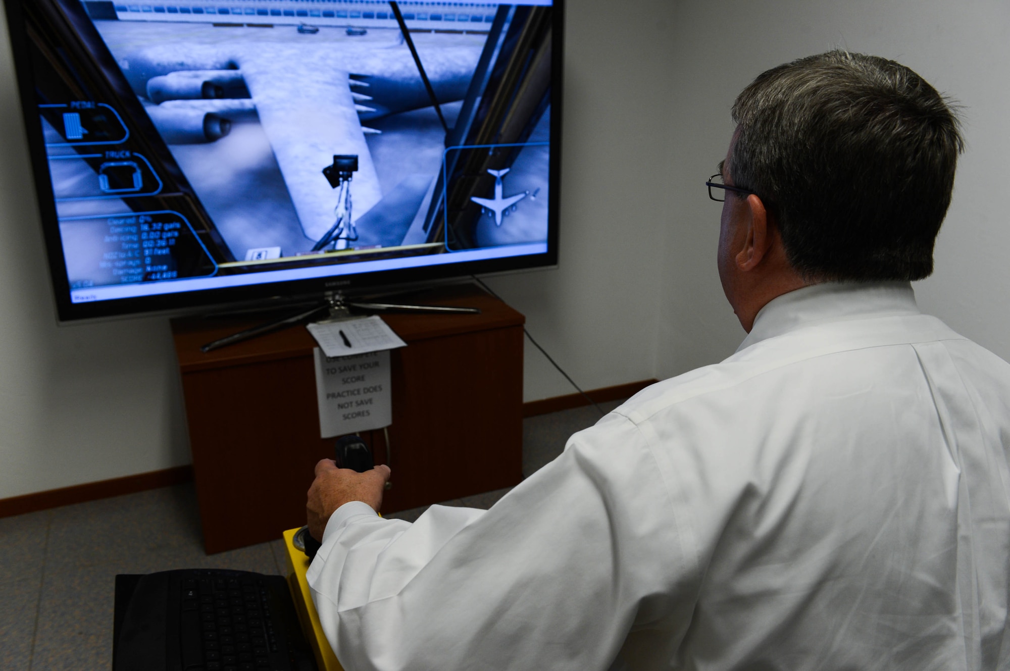 Brian Duffy, Veterans of Foreign Wars junior vice commander-in-chief, de-ices an aircraft in a simulator at the 726th Air Mobility Squadron at Spangdahlem Air Base, Germany, Aug. 7, 2014. Duffy and Robert Wallace, VFW executive director, visited the base to discuss quality of life issues with Airmen. (U.S. Air Force photo by Airman 1st Class Kyle Gese/Released)