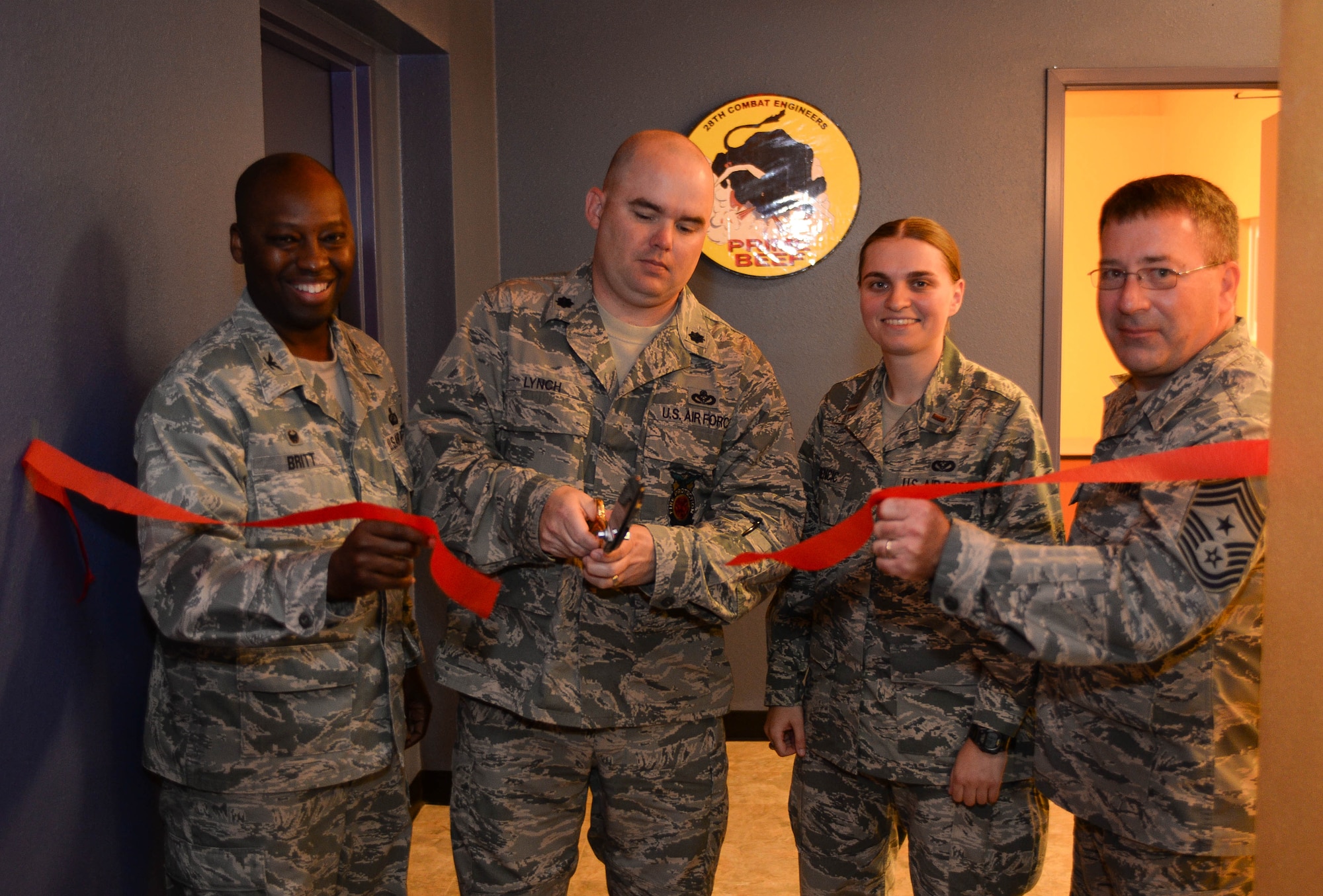 Col. Kerry Britt, 28th Mission Support Group commander, Lt. Col. Nicholas Lynch, 28th Civil Engineer Squadron commander, 2nd Lt. Amela Kamencic, 28th Civil Engineer Squadron environmental project manager, and Chief Master Sgt. Kevin Peterson, 28th Bomb Wing command chief, cut the ribbon to the base’s newly-renovated Higher Grounds Café, during an open house event at Ellsworth Air Force Base, S.D., July 31, 2014. The event celebrated the finished renovations to the café in an effort to improve quality of life for Airmen. (U.S. Air Force photo by Senior Airman Zachary Hada/Released)