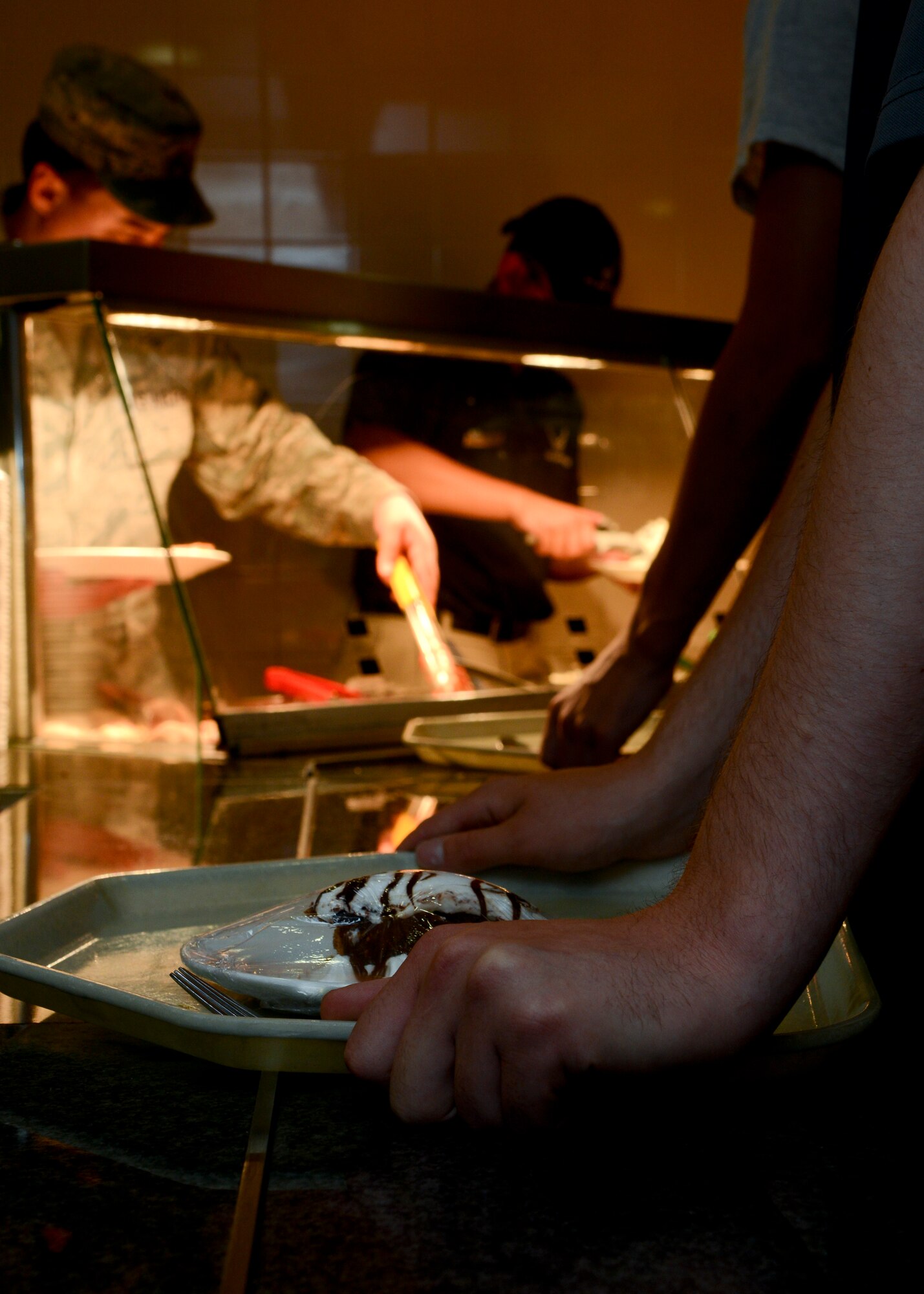 Team Mildenhall Airmen wait in line during the Airmen Appreciation Meal, Aug. 7, 2014 at the Gateway Dining Facility on RAF Mildenhall, England. The dinner menu featured lobster tail, strip loin steak and chicken parmesan, baked potatoes and a variety of side dishes. (U.S. Air Force photo/Airman 1st Class Victoria H. Taylor/Released)