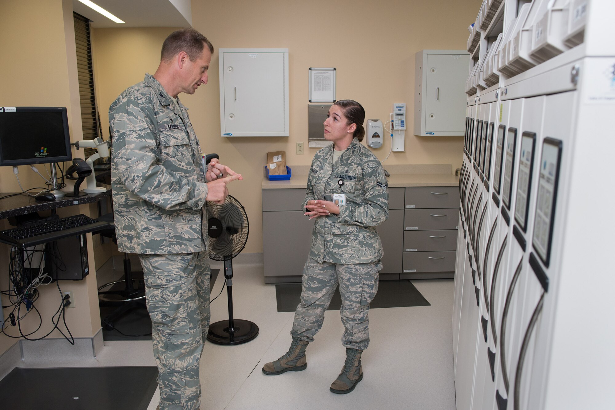 Col. Corey Martin, 60 Air Mobility Wing commander, discusses pharmacy operations with Airman 1st Class Ashley Deason at David Grant Medical Center. Martin shadowed the pharmacy specialist Aug. 5, 2014, as part of the Golden Bear Shadow Program. (U.S. Air Force photo/Ken Wright)