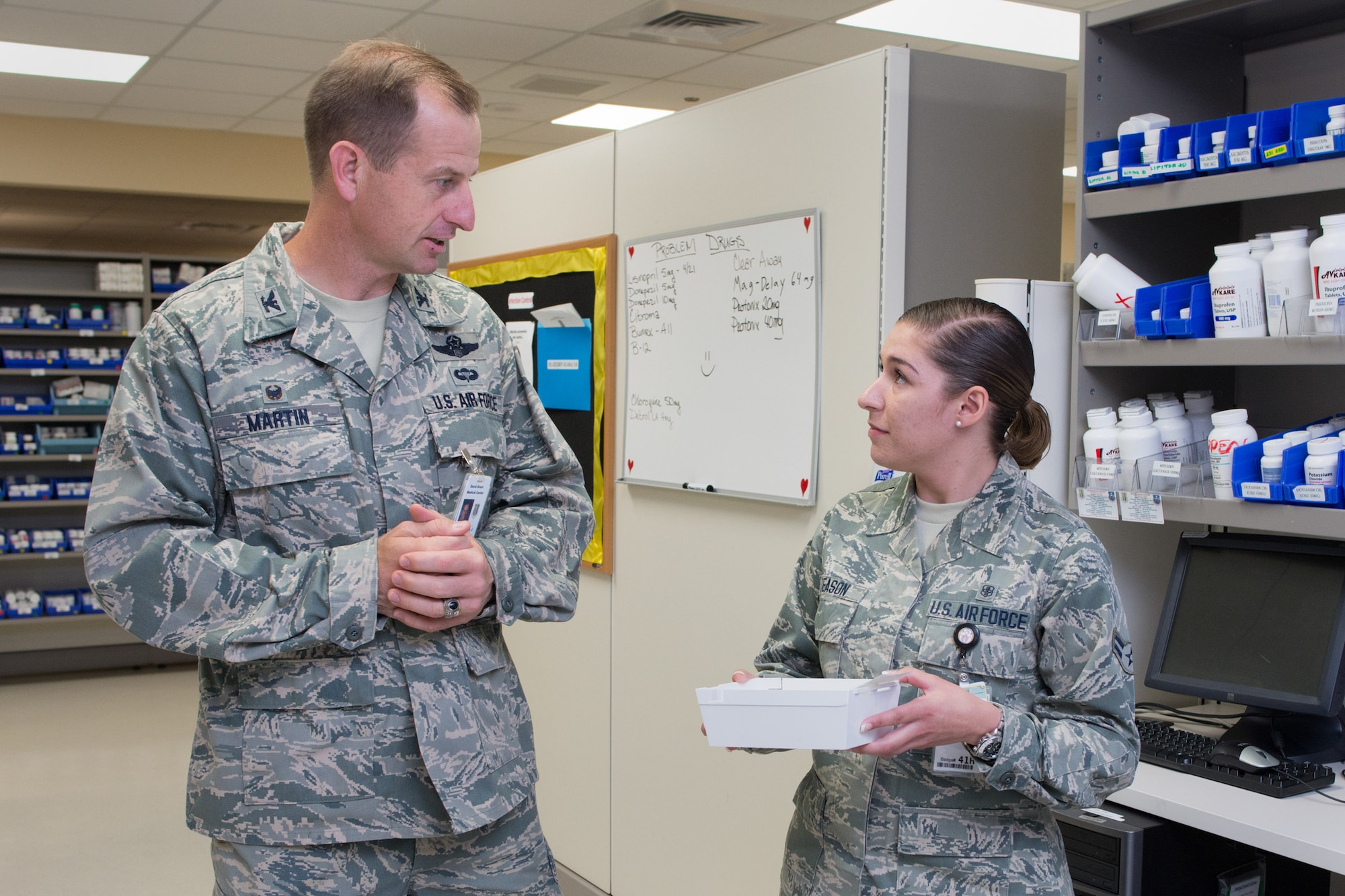 Col. Corey Martin, 60 Air Mobility Wing commander, discusses pharmacy operations with Airman 1st Class Ashley Deason at David Grant Medical Center. Martin shadowed the pharmacy specialist Aug. 5, 2014, as part of the Golden Bear Shadow Program. (U.S. Air Force photo/Ken Wright)