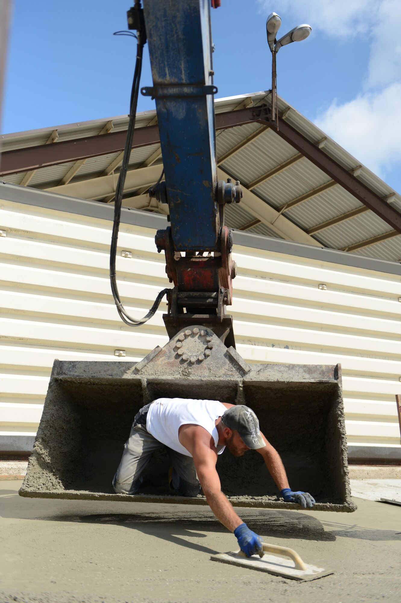 Daniel Kuhn, German contractor, smoothes wet concrete during construction on the flightline at Spangdahlem Air Base, Germany, Aug. 7, 2014. The construction is meant to replace the concrete slabs of the entire ramp because they have reached their life expectancy and began to crack. (U.S. Air Force photo by Senior Airman Gustavo Castillo/Released) 