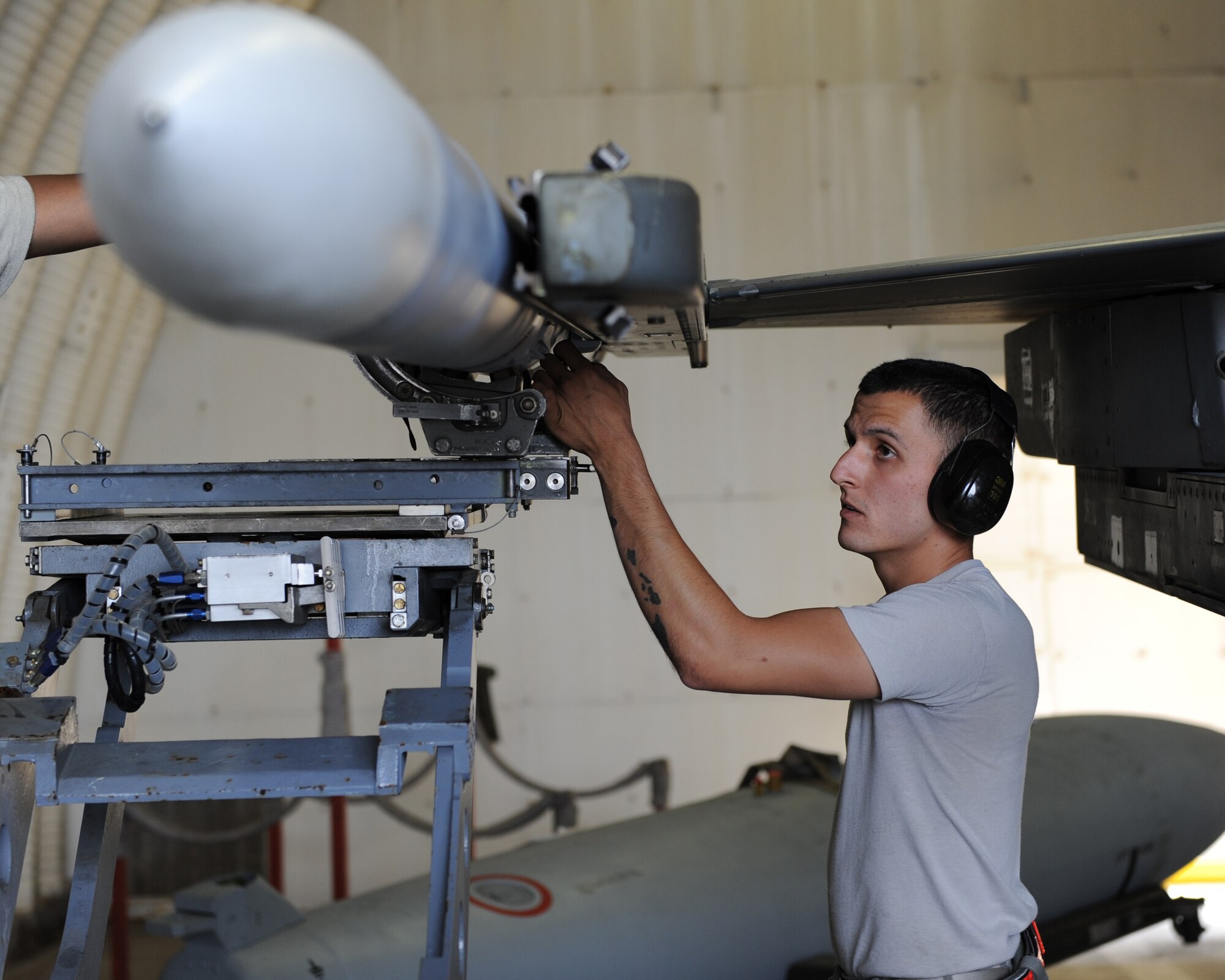U.S. Air Force Staff Sgt. Earl Condra, 480th Aircraft Maintenance Unit aircraft armament specialist from Honolulu, loads training munitions onto a U.S. Air Force F-16 Fighting Falcon fighter aircraft during a base exercise Aug. 6, 2014, at Spangdahlem Air Base, Germany. Standardization crew members inspected the load crew on safety and protocol. (U.S. Air Force photo by Airman 1st Class Dylan Nuckolls/Released) 