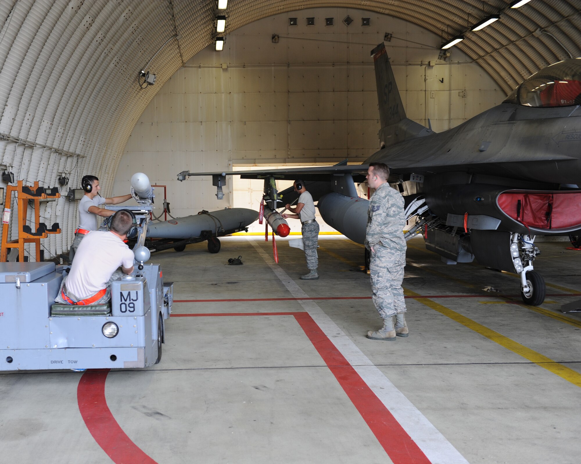 U.S. Air Force aircraft armament specialists from the 480th Aircraft Maintenance Unit load training munitions onto a U.S. Air Force F-16 Fighting Falcon fighter aircraft during a base exercise Aug. 6, 2014, at Spangdahlem Air Base, Germany. Standardization crew members inspected the 480th AMU to ensure they maintain safety and follow protocol. (U.S. Air Force photo by Airman 1st Class Dylan Nuckolls/Released)