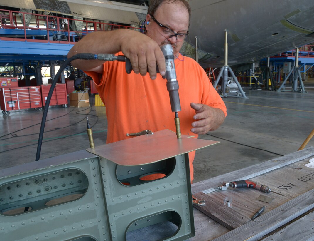 Terry Talcott, a 559th Aircraft Maintenance Squadron sheet metal mechanic, drills a fixed fairing for a C-17, August 5, 2014. (U.S. Air Force photo by Ray Crayton)