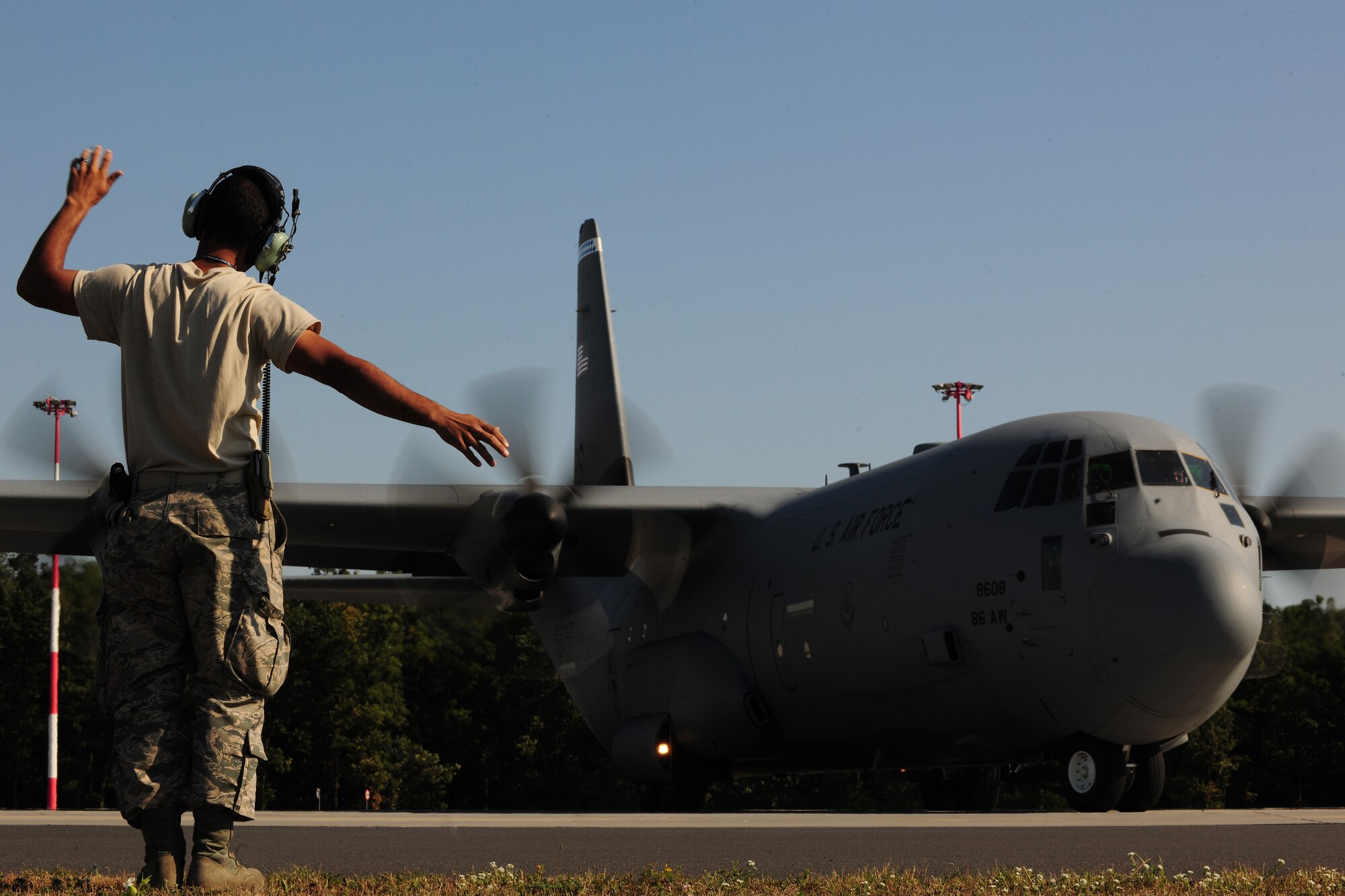 U.S. Air Force Senior Airman Christopher Guerrero, 86th Aircraft Maintenance Squadron aircraft maintainer, directs a C-130J Super Hercules as it taxis down the flightline at Powidz Air Base, Poland, Aug. 7, 2014. Two C-130s were deployed from Ramstein Air Base, Germany as part of a multi-national flying training deployment in support of Operation Atlantic Resolve. (U.S. Air Force photo by Staff Sgt. Jarad A. Denton/Released)