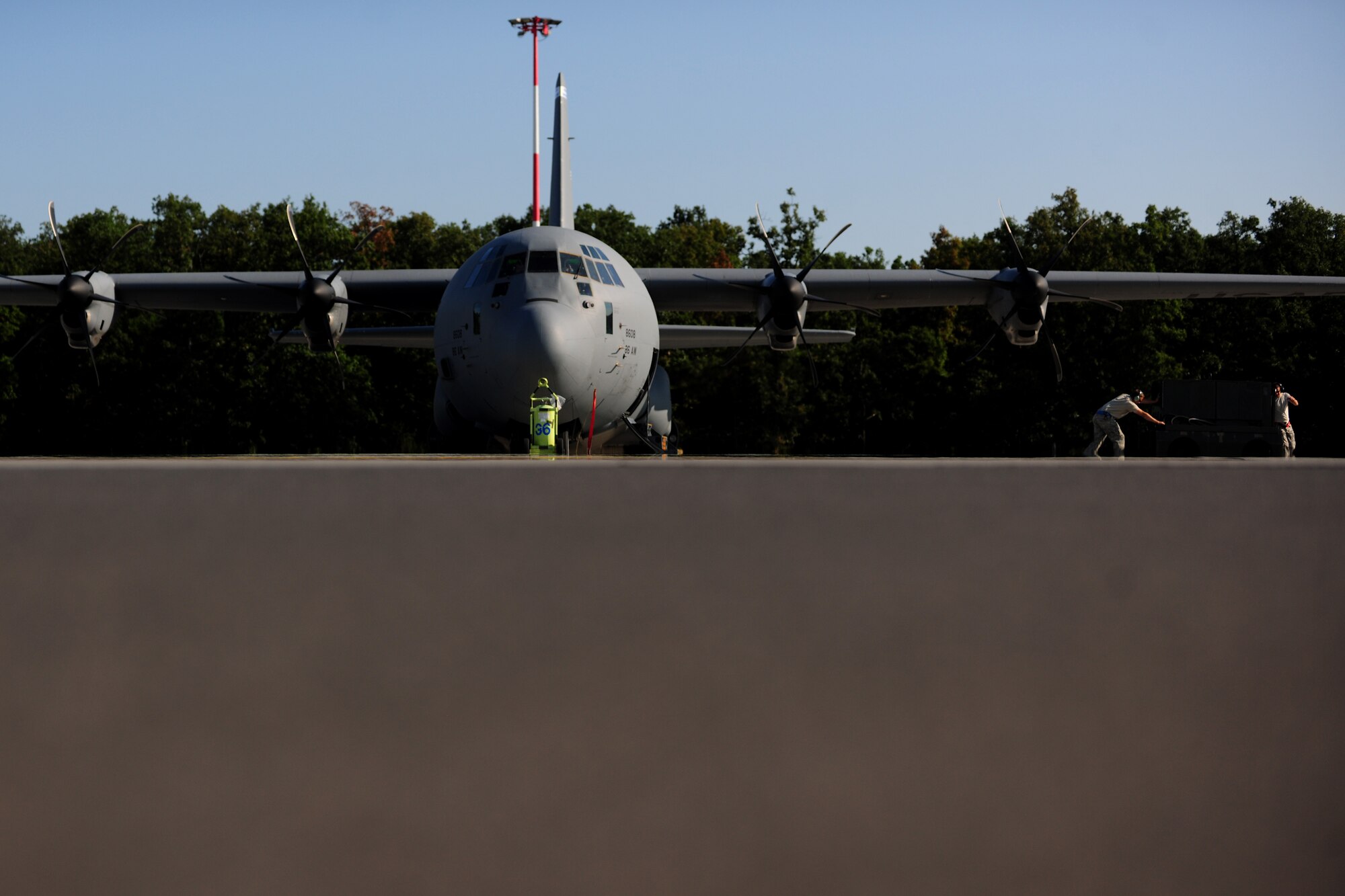 Two Airmen from the 86th Aircraft Maintenance Squadron clear equipment away from a C-130J Super Hercules preparing for takeoff during a flying training deployment at Powidz Air Base, Poland, Aug. 7, 2014. Throughout this deployment, the aircraft participated in bilateral training that tested the air and personnel drop skills of U.S. military personnel and NATO partners throughout the region. (U.S. Air Force photo by Staff Sgt. Jarad A. Denton/Released)