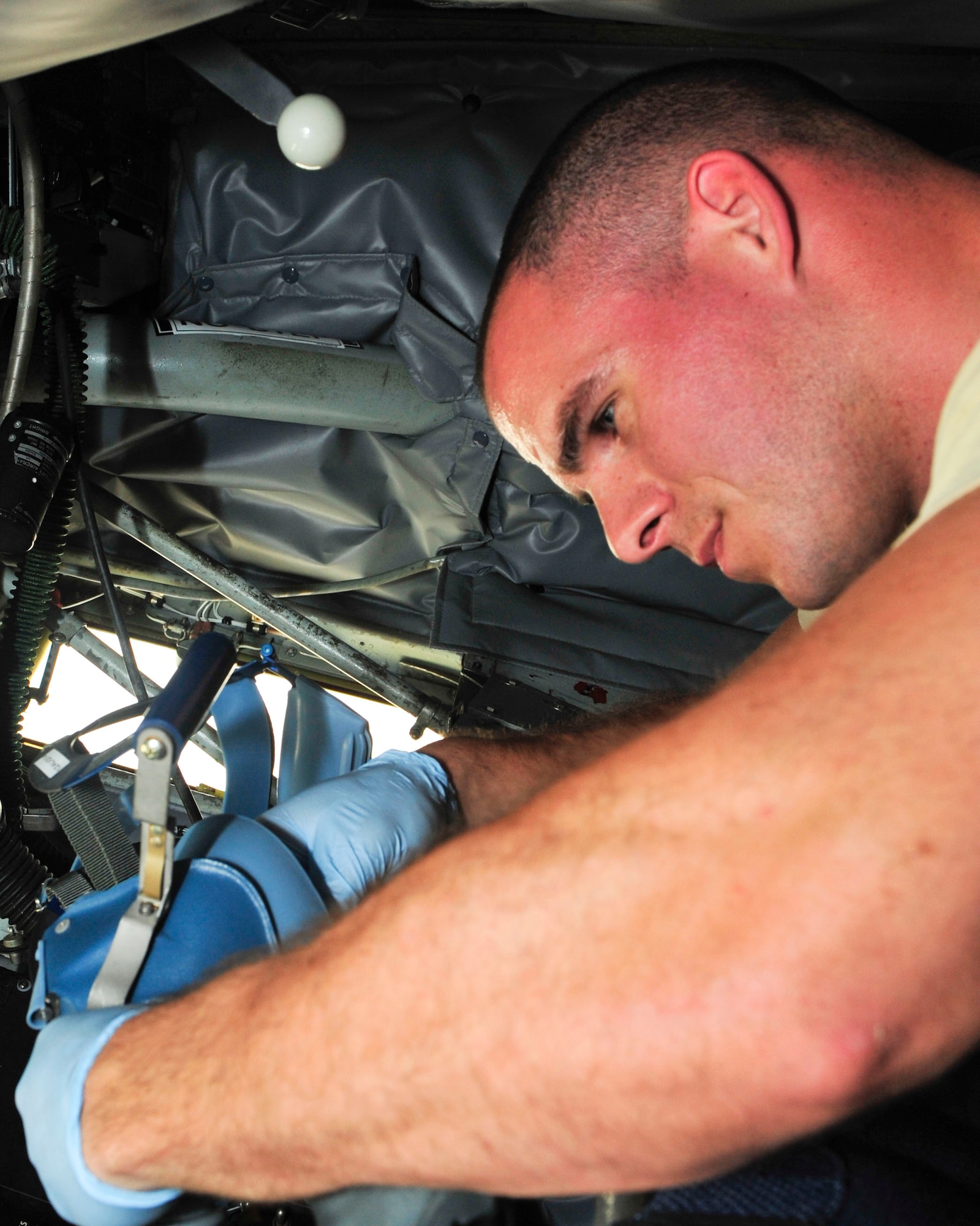 U.S. Air Force Senior Airman Kevin Robinson, 340th Expeditionary Air Refueling Squadron Detachment 1 aircrew flight equipment technician, inspects equpiment after a refueling mission at Mazar-i-Sharif Airfield, July 24, 2014. Robinson inspects every piece of flight crew equipment that is attached to the 340th EARS Det. 1, and also he maintains the shop responsibilities as a one man crew. Robinson is deployed from Macdill, Air Force Base, Florida and his hometown is Massfield, Massachusetts. (U.S. Air Force photo by Senior Airman Colin Cates)  