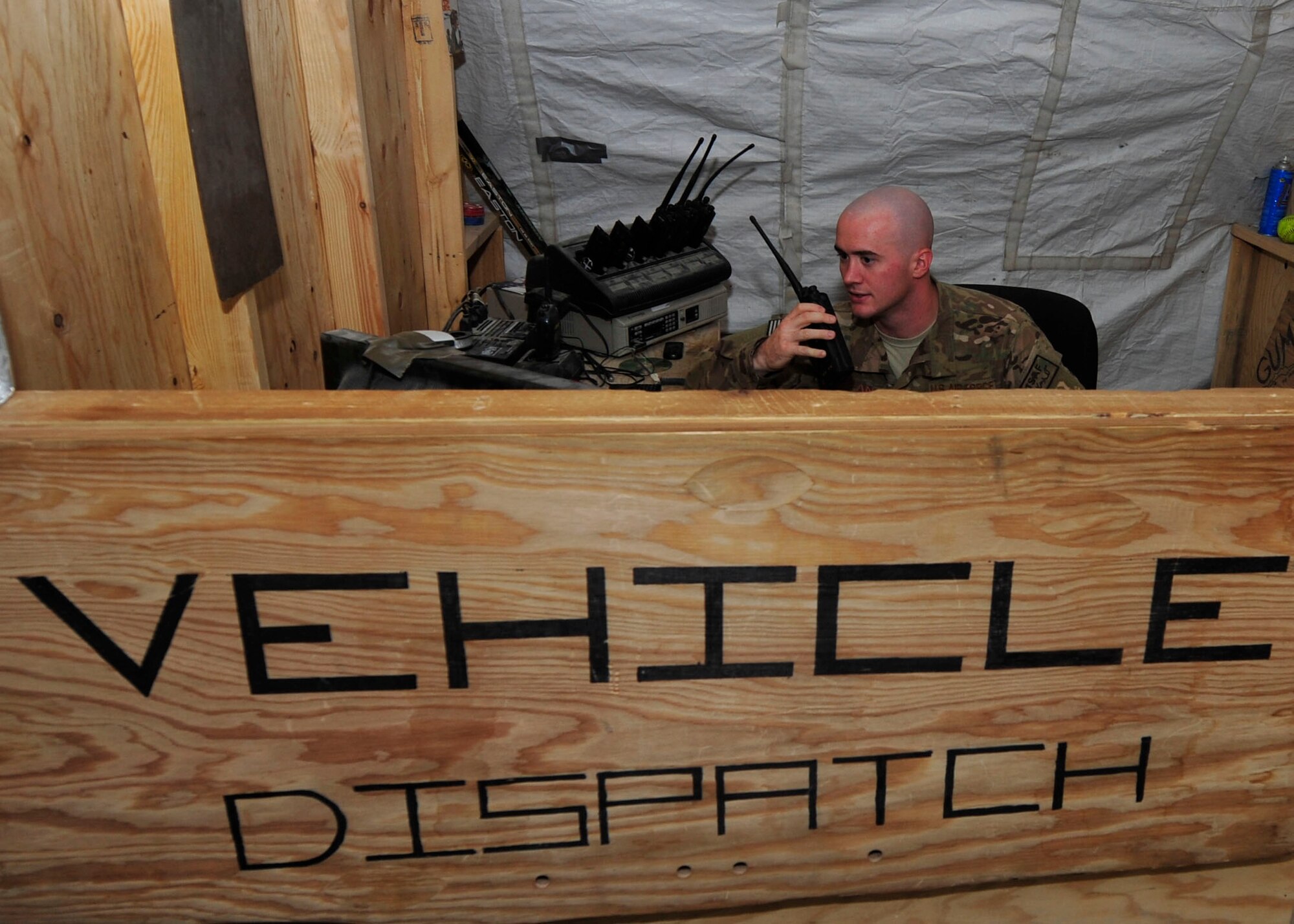 U.S. Air Force Senior Airman Andrew Swan, 340th Expeditionary Air Refueling Squadron Detachment 1 vehicle operator,  answers a customer's call over the radio at Mazar-i-Sharif Air field, July 24, 2014. Vehicle opertors transport over 100 Airmen to and from work every day. Swan is deployed from Davis Monthan Air Force Base, Arizona. (U.S. Air Force photo by Senior Airman Colin Cates) 
