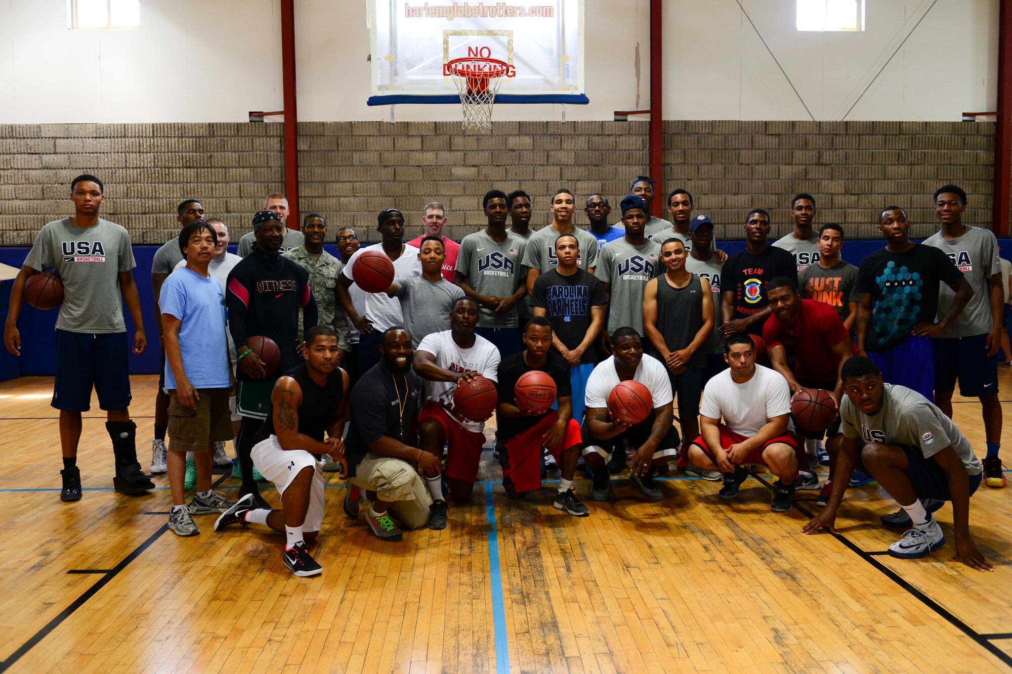 Service members and members of the United States Basketball Under 17 Team pose for a group photo at Al Udeid Air Base, Qatar, Aug. 5, 2014. The team visited AUAB on their way to Dubai, United Arab Emirates, for the 2014 International Basketball Federation World Championship, where they will compete against countries from around the world. (U.S. Air Force photo by Staff Sgt. Ciara Wymbs)