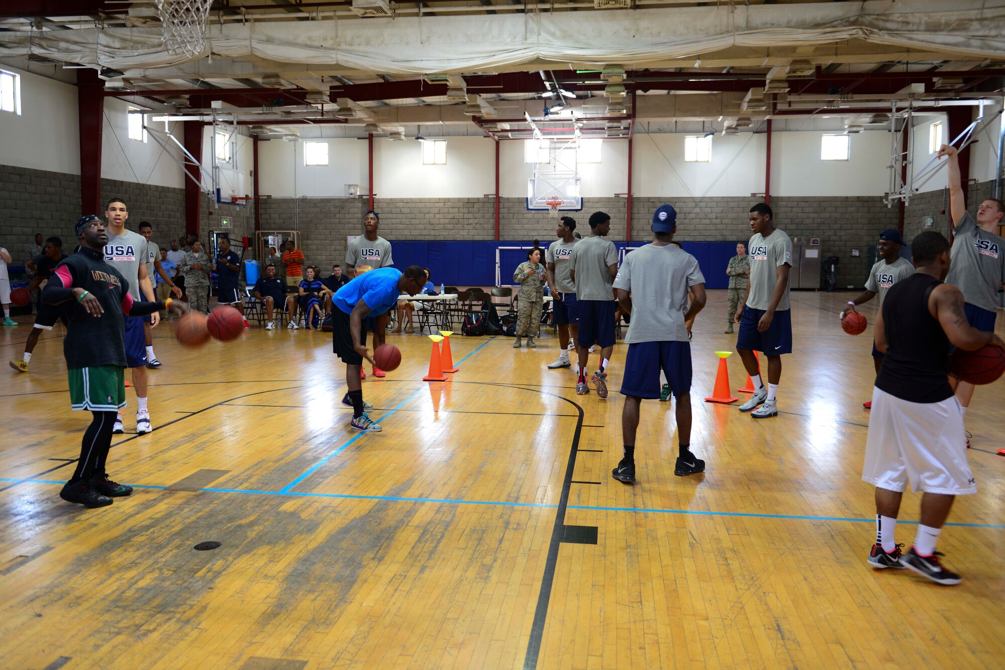 Service members and members of the United States Basketball Under 17 Team practice before a three point shoot-out competition at Al Udeid Air Base, Qatar, Aug. 5, 2014. Service members and the team competed in who can make as many baskets as possible in 30 seconds. (U.S. Air Force photo by Staff Sgt. Ciara Wymbs) 