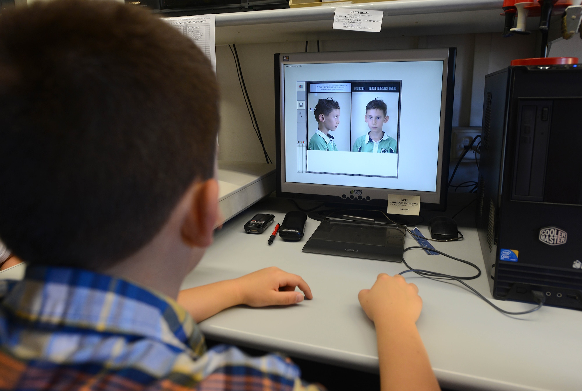 Dominic Fosco, son of Master Sgt. Jason Fosco, takes his mugshot, Aug. 6, 2014, during a tour of the Pordenone Carabinieri office. The Aviano Youth Program has provided 30 different camps throughout the summer that allowed the kids hands-on knowledge of things they were interested in. (U.S. Air Force photo/Airman 1st Class Deana Heitzman)