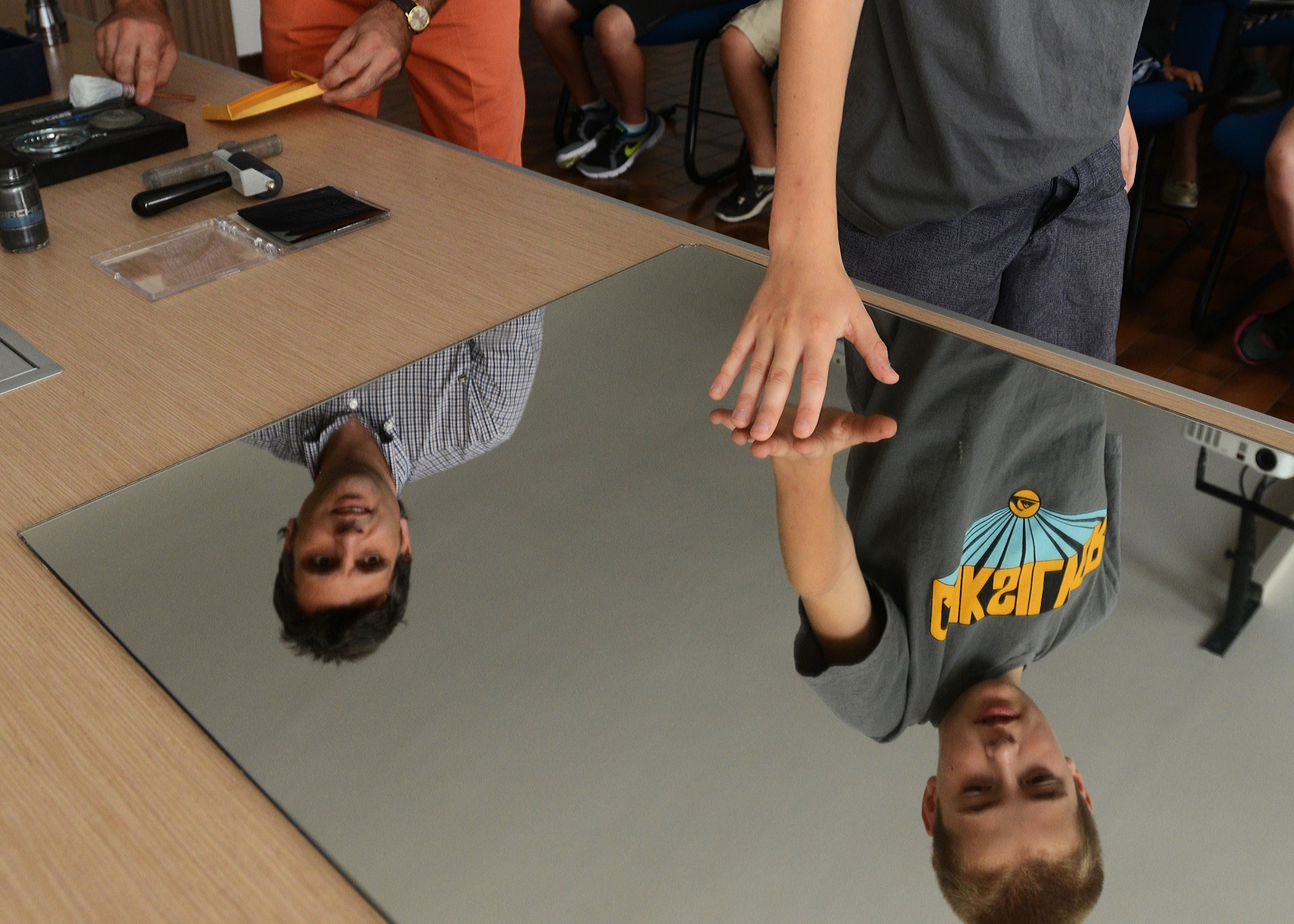 An Italian crime scene investigator and Anthony Cyr, son of Phillip and Ann Gwaltney, demonstrate how to retrieve fingerprints from a crime scene, Aug. 6, 2014, at the Pordenone Carabinieri office. During the trip to Pordenone’s Crime Scene Investigations unit, participants had their mug shots taken and were fingerprinted as part of the tour. (U.S. Air Force photo/Airman 1st Class Deana Heitzman)