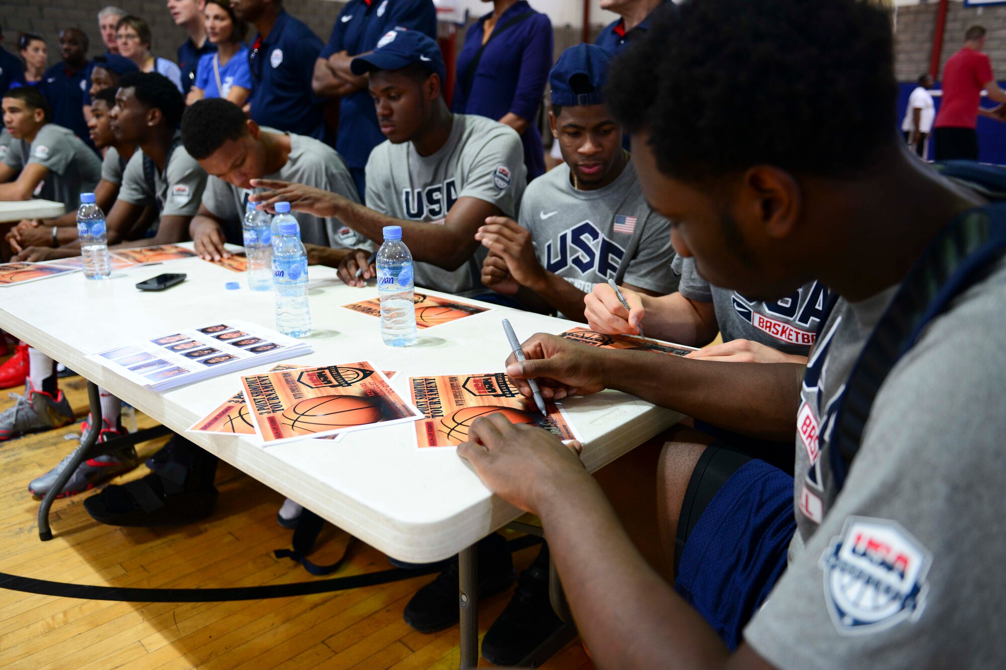 Members of the United States Basketball Under 17 Team sign autographs at Al Udeid Air Base, Qatar, Aug. 5, 2014. The team visited AUAB on their way to Dubai, United Arab Emirates, for the 2014 International Basketball Federation World Championship. (U.S. Air Force photo by Staff Sgt. Ciara Wymbs)  