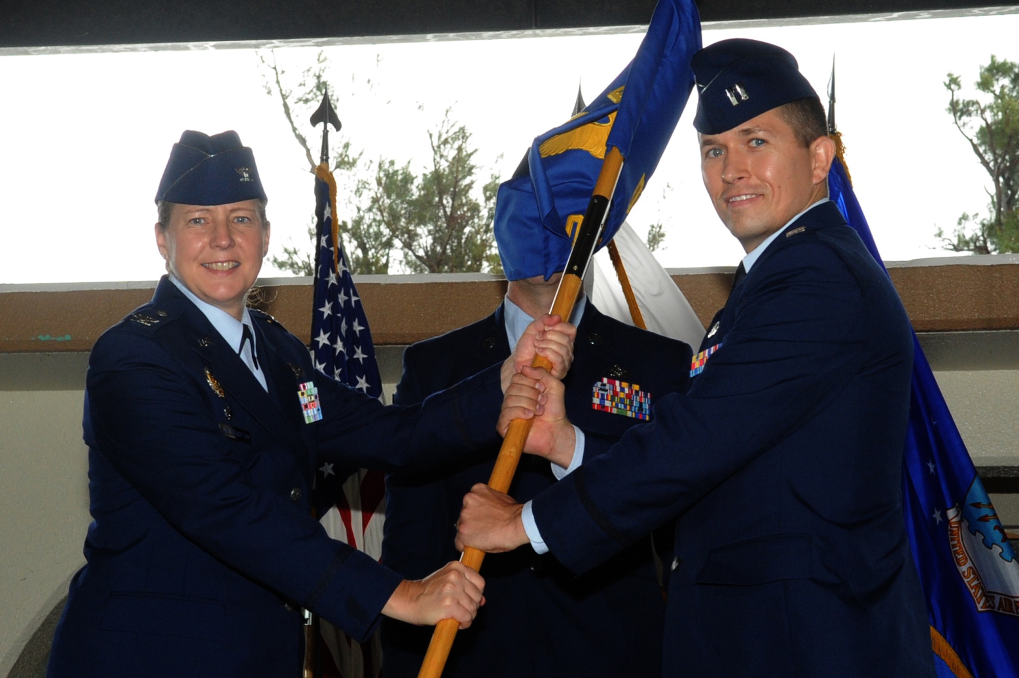 U.S. Air Force Col. Kathleen Weatherspoon, 18th Force Support Squadron commander, passes the guidon to Capt. Adam L. Baker, Detachment 1, 18th Force Support Squadron commander, during his change of command ceremony at the Okuma Recreation Facility on Okinawa, Japan, Aug. 8, 2014. Baker is taking command of nine military personnel from five different Air Force career fields, three U.S. civilians and over 100 local nationals from eight diverse activities, while controlling a $750,000 operating budget and capital assets. (U.S. Air Force photo by Airman 1st Class Zackary A. Henry/Released)