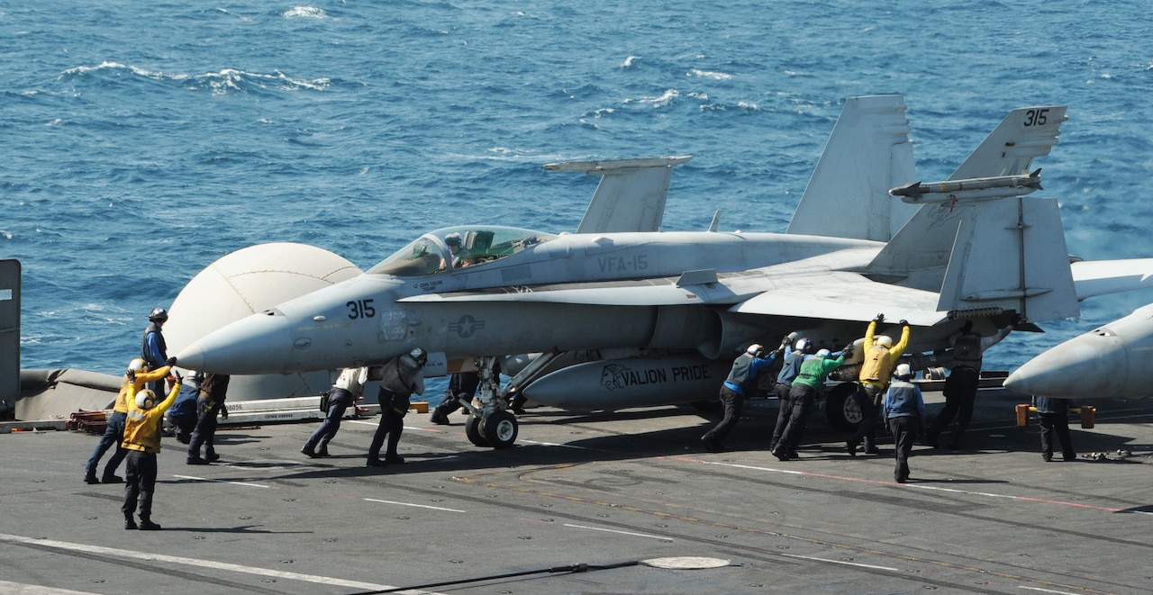 Sailors guide an F/A-18C Hornet assigned to the Valions of Strike Fighter Squadron 15 on the flight deck of the aircraft carrier USS George H.W. Bush, Aug. 8, 2014. The carrier is supporting maritime security operations and theater security cooperation efforts in the U.S. 5th Fleet area of responsibility. U.S. Navy photo by Petty Officer 3rd Class Lorelei Vander Griend
