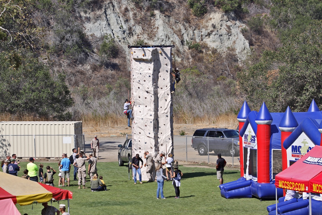 Marines and their loved ones participate in a rock climbing event during a Jane Wayne Day event at the School of Infantry here, Aug. 9.

The day started off with one group breaking off to learn how to operate different weapons systems such as the M16 service rifle and the M9 service pistols using the Indoor Simulated Marksmanship Trainer. They travelled to Range 210C to conduct a live-fire shoot with the M27 Infantry Automatic Rifle.

"It was a fun experience," said Kaylee Walter, whose husband serves as the executive officer for India Company, Marine Combat Training Battalion, SOI-W. "It was surprising how heavy the weapon was and how hard it was to hit the target. It really gave me a whole new understanding and appreciation as to what my husband does."
