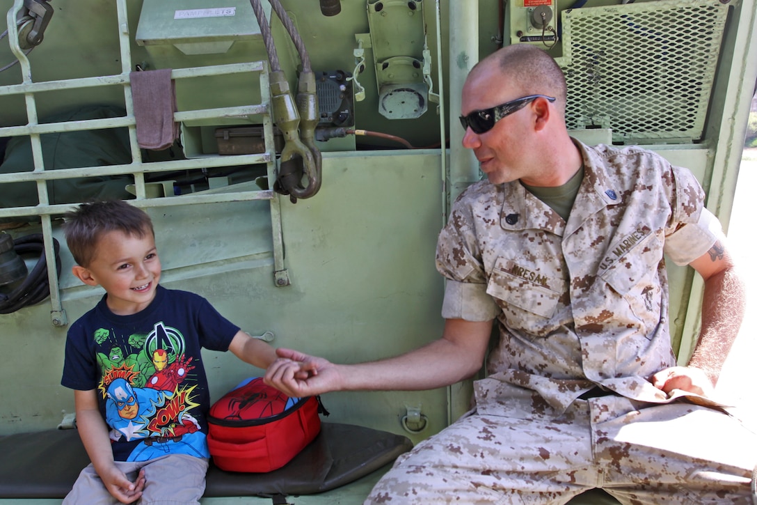Staff Sgt. Ryan Kresan, platoon sergeant with Assault Amphibian School Battalion, shakes hands with Teagan Perkins, four, inside an amphibious assault vehicle during a Jane Wayne Day event at the School of Infantry here, Aug. 9.

The day started off with one group breaking off to learn how to operate different weapons systems such as the M16 service rifle and the M9 service pistols using the Indoor Simulated Marksmanship Trainer. They travelled to Range 210C to conduct a live-fire shoot with the M27 Infantry Automatic Rifle.

"It was a fun experience," said Kaylee Walter, whose husband serves as the executive officer for India Company, Marine Combat Training Battalion, SOI-W. "It was surprising how heavy the weapon was and how hard it was to hit the target. It really gave me a whole new understanding and appreciation as to what my husband does."