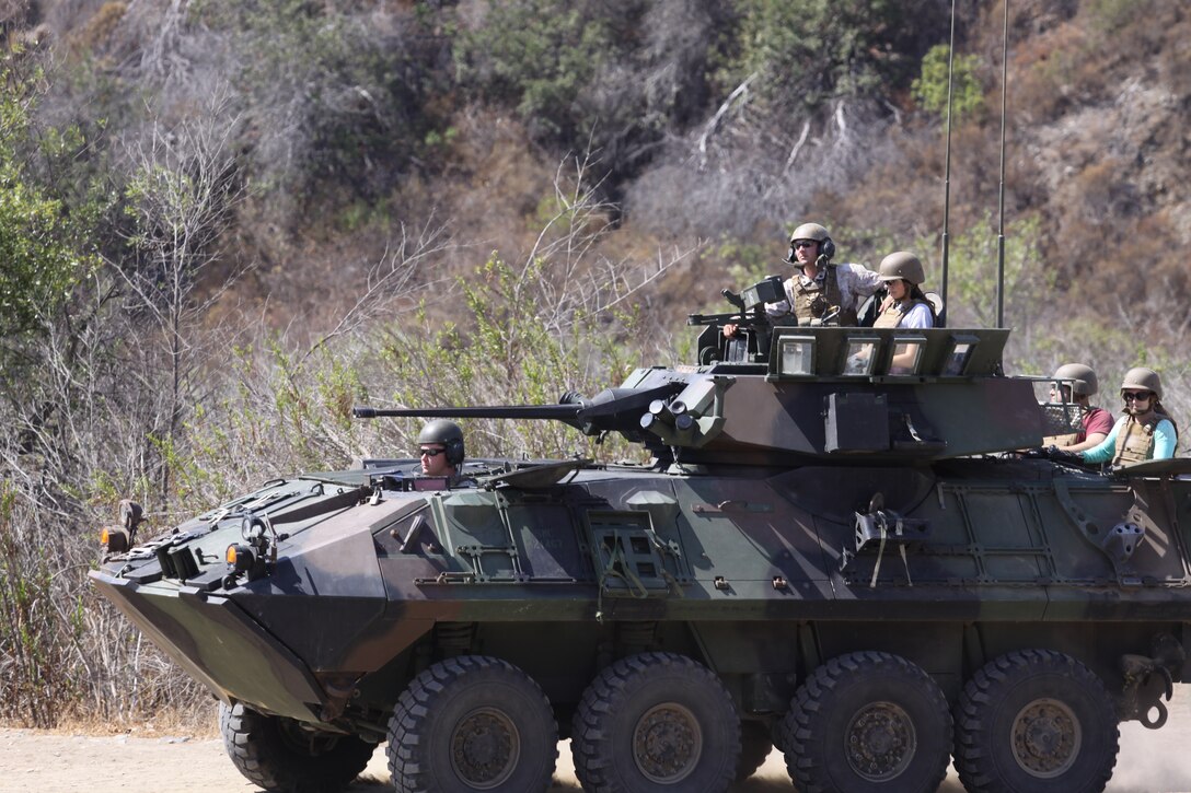Loved ones and family members of Marines ride a light armored vehicle during a Jane Wayne Day event at the School of Infantry here, Aug. 9.

The day started off with one group breaking off to learn how to operate different weapons systems such as the M16 service rifle and the M9 service pistols using the Indoor Simulated Marksmanship Trainer. They travelled to Range 210C to conduct a live-fire shoot with the M27 Infantry Automatic Rifle.

"It was a fun experience," said Kaylee Walter, whose husband serves as the executive officer for India Company, Marine Combat Training Battalion, SOI-W. "It was surprising how heavy the weapon was and how hard it was to hit the target. It really gave me a whole new understanding and appreciation as to what my husband does."