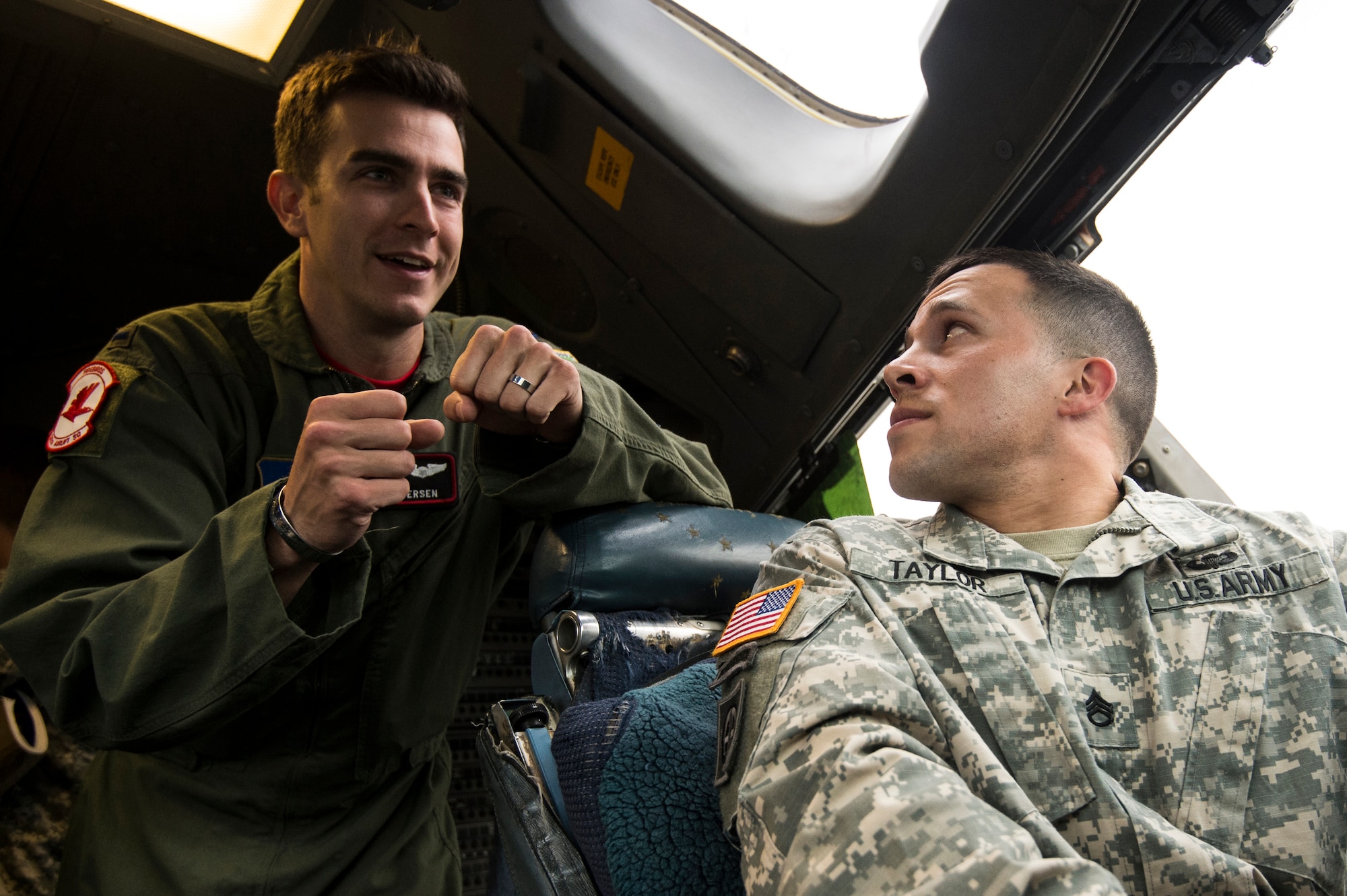 U.S. Air Force 1st Lt. Ryan Vesen, 517th Airlift Squadron pilot, answers questions from U.S. Army Staff Sgt. Christopher Taylor, 4-25 Airborne Brigade Combat Team, inside a C-17 Globemaster III at Joint Base Elmendorf- Richardson, Alaska, Aug. 8, 2014. The 517th AS was showing support for local Army jumpers by giving them a tour of the aircraft and answering questions. (U.S. Air Force photo by Staff Sgt. Stephany Richards/ Released)