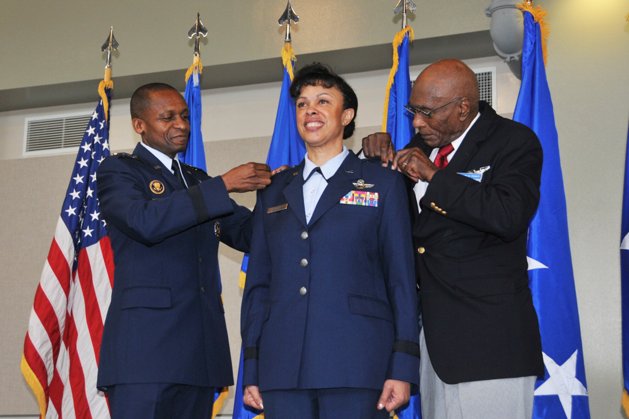 Gen. Darren W. McDew, Air Mobility Command commander, and Hillard W. Pouncy, original Tuskegee Airman, pin stars on Maj. Gen. Stayce D. Harris, during a promotion ceremony Aug. 9, 2014 at Dobbins Air Reserve Base, Ga. Harris assumed command of 22nd Air Force and will oversee 15,000 Reservists and 105 unit-equipped aircraft. She will have command supervision of the Reserve's air mobility operations and other vital mission sets. Reserve aircrews within 22nd Air Force fly a variety of missions to include aerial spraying, fire suppression, hurricane hunters to troop transport utilizing the C-130 Hercules. (U.S. Air Force photo/Staff Sgt. Jaclyn McDonald)