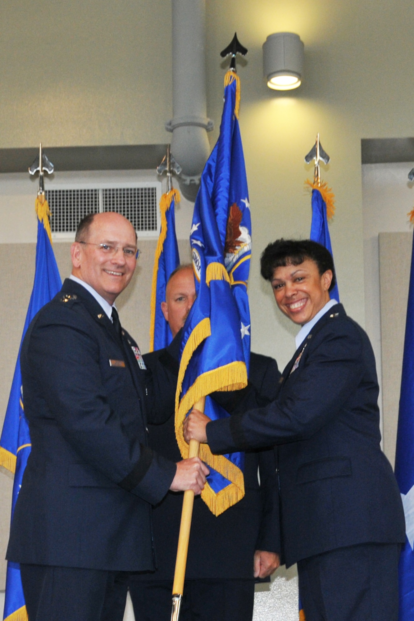 Lt. Gen. James “JJ” Jackson,  chief of Air Force Reserve, Headquarters U.S. Air Force, Washington, D.C., and commander, Air Force Reserve Command, passes the 22nd Air Force Flag to Maj. Gen. Stayce D. Harris, during an assumption of command ceremony Aug. 9, 2014 at Dobbins Air Reserve Base, Ga. Harris will oversee 15,000 Reservists and 105 unit-equipped aircraft. She will have command supervision of the Reserve's air mobility operations and other vital mission sets. Reserve aircrews within 22nd Air Force fly a variety of missions to include aerial spraying, fire suppression, hurricane hunters to troop transport utilizing the C-130 Hercules. (U.S. Air Force photo/Staff Sgt. Jaclyn McDonald)