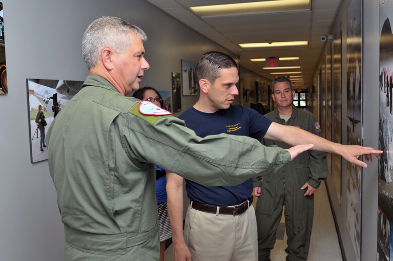 Col. Shawn Clouthier, 109th Airlift Wing commander, points out photos highlighting the Wing's mission to Assemblyman Angelo Santabarbara, 111th District, during a tour at Stratton Air National Guard Base, Scotia, New York, on Aug. 9, 2014. Santabarbara learned about the 109th's unique mission and also got to see the inside of an LC-130 Skibird. (U.S. Air National Guard photo by Staff Sgt. Benjamin German/Released)
