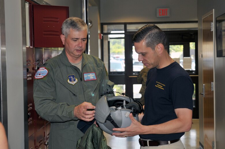 Col. Shawn Clouthier, 109th Airlift Wing commander, shows Assemblyman Angelo Santabarbara, 111th District, a pilot's helmet during a tour at Stratton Air National Guard Base, Scotia, New York, on Aug. 9, 2014. Santabarbara learned about the 109th's unique mission and also got to see the inside of an LC-130 Skibird. (U.S. Air National Guard photo by Staff Sgt. Benjamin German/Released)