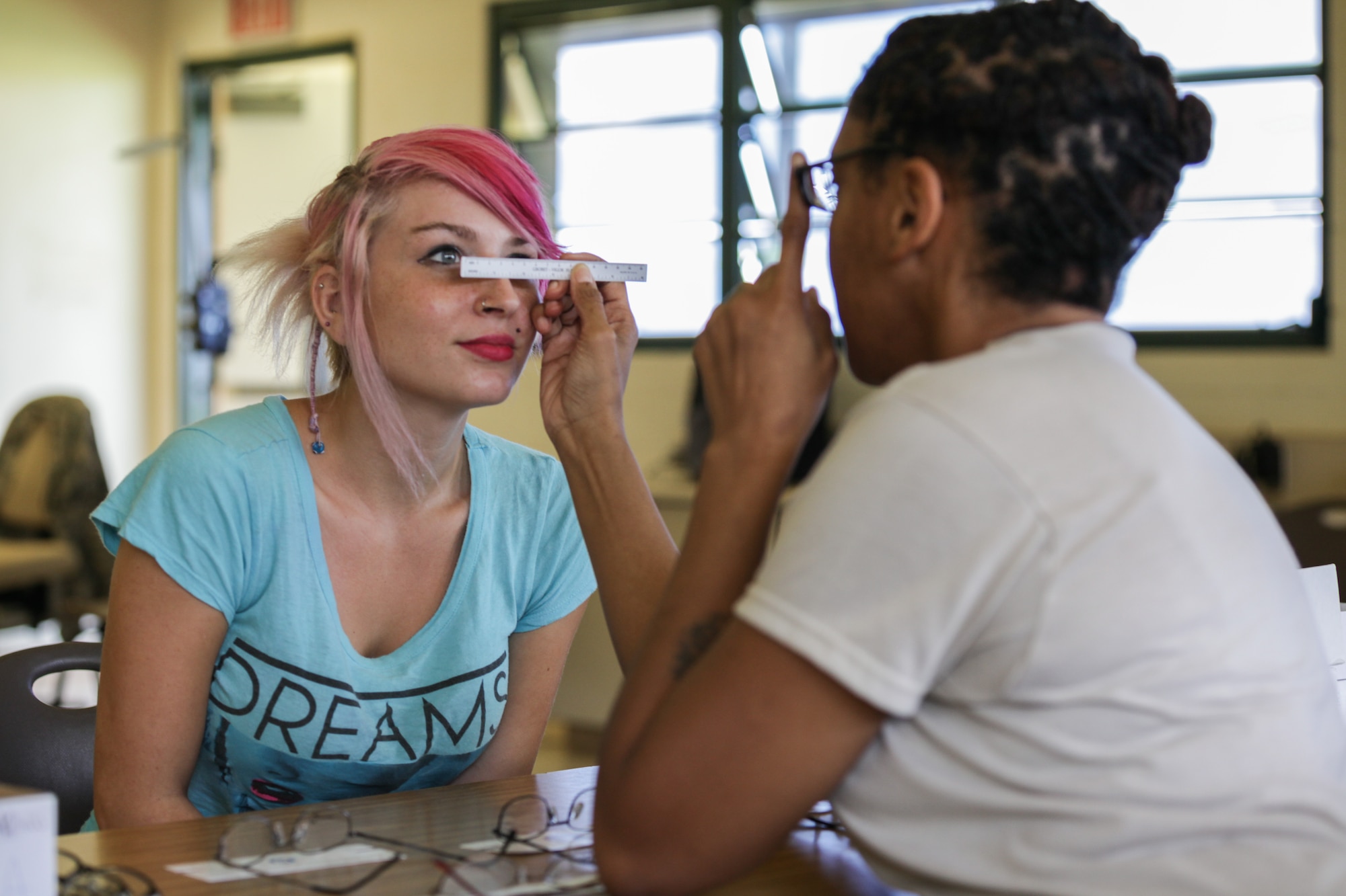 KAUAI, HAWAII – U.S. Air Force Tech. Sgt. Joy Wiggs, 440th  Medical Squadron, Pope Army Airfield, N.C., measures the distance between Kapa'a local Kamariah Dumont's pupils to select the proper frame size during Tropic Care 2014 at Kapa'a Middle School, Kapa'a, Hawaii, June 19.   Tropic Care 2014 is an Innovative Readiness Training exercise and provides real world training in a joint civil and military environment while delivering world class medical care to the people of Kauai, Hawaii. (U.S. Army photo by Spc. Cory Long/Released)