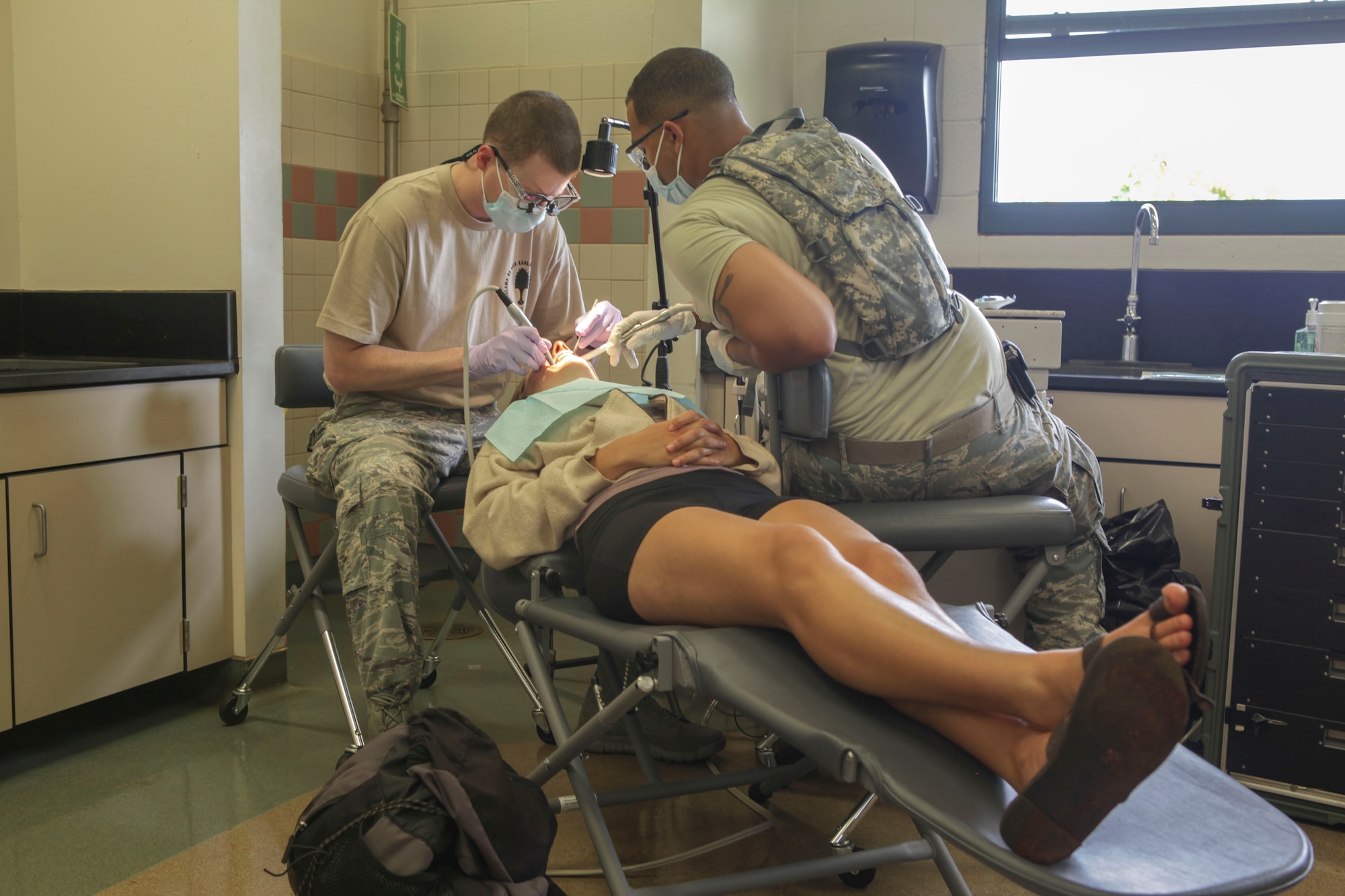 KAUAI, HAWAII – U.S. Air Force Capt. Bryan Roach (left), 440th Medical Squadron, Pope Army Airfield, N.C., and Senior Airman Vincent Gerrich, 911st AeroMedical Staging Squadron, Pittsburgh International Airport Air Reserve Station, P.A., perform a dental exam for a local patient during Tropic Care 2014 at Kapa'a Middle School, Kapa'a, Hawaii, June 17.  Tropic Care 2014 an Innovative Readiness Training exercise, provides real-world training in a joint civil-military environment while delivering world class medical care to the people of Kauai, Hawaii. (Photo by U.S. Army SSG Daniel Bellamy/Released)