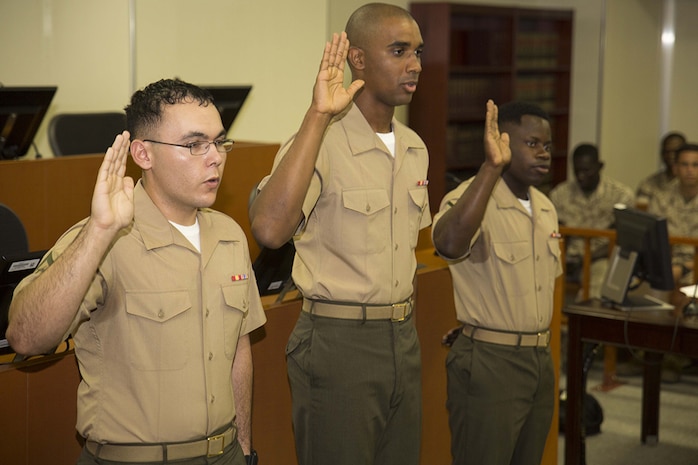 From left to right, Lance Cpl. Jorge Meza, Lance Cpl. Shaqueal Coote, and Pfc. Kervens Beauplan recite the Oath of Allegiance aboard Marine Corps Air Station Iwakuni, Japan, July 17, 2014. Before the oath, the Marines were interviewed about U. S. history by Walter Haith, the field office director of U.S. Citizenship and Immigration Services Attaché, Republic of Korea and Japan.