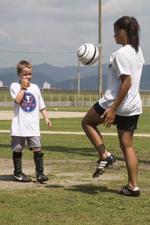 Kalaila Holt, a member of the Southern California Seahorse Soccer Club, practices juggling techniques with a Seahorse soccer camp participant at Penny Lake fields aboard Marine Corps Air Station Iwakuni, Japan, July 23, 2014. The Seahorses are a motivational, religious soccer team who carry out numerous after-school clinics, camps, international tours and many other outreach programs throughout Asia and the U.S. west coast.