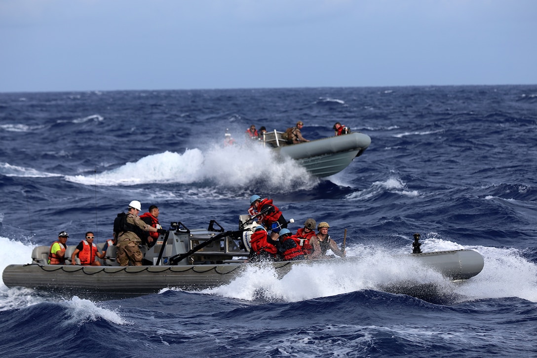 Sailors with the USS San Diego and Marines with the 11th Marine Expeditionary Unit return to the USS San Diego on rigid inflatable boats with recovered researchers with  the National Oceanic and Atmospheric Administration as part of a recovery mission, Aug. 8, 2014.  Marines and sailors from the 11th MEU and Makin Island Amphibious Ready Group team recovered 11 personnel from three isolated islands more than 900 nautical miles northwest of Hawaii and directly in the path of Hurricane Iselle. MEU aircraft transported the researchers to Midway Atoll where they could seek shelter from the storm.  (U.S. Marine Corps photo by Gunnery Sgt. Rome M. Lazarus/Released)