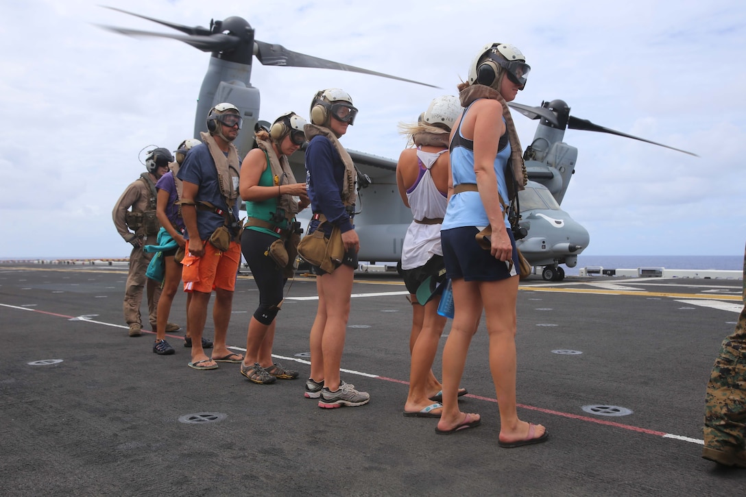 National Oceanic Atmospheric Administration (NOAA) personnel standby before being escorted onto an MV-22B Osprey en route to Midway Atoll, Hawaii as part of the MEU’s WESTPAC 14-2 deployment Aug. 8, 2014. The recovery of NOAA personnel was executed because of the threat of hurricane Iselle, the first hurricane to strike the Hawaii islands in more than two decades, which threatened the safety of the researchers. (U.S. Marine Corps photo by Cpl. Demetrius Morgan/RELEASED)
