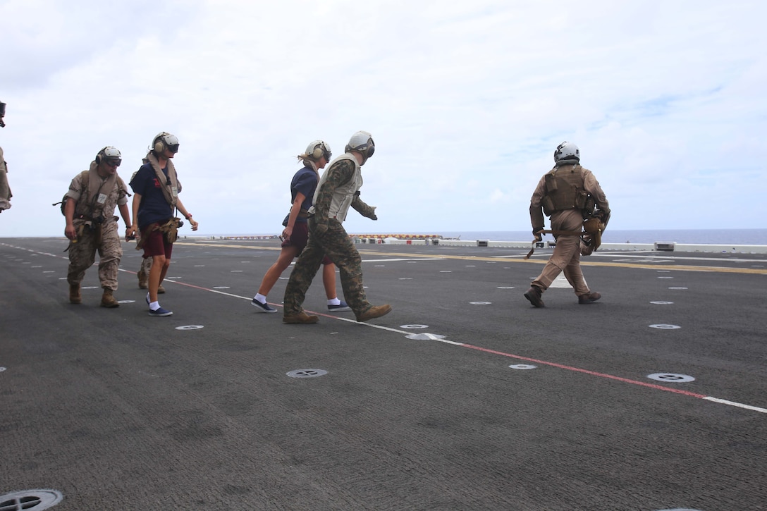 Marines with the 11th Marine Expeditionary Unit escort National Oceanic and Atmospheric Administration (NOAA) personnel onto an MV-22B Osprey en route to Midway Atoll aboard the USS Makin Island, during the MEU’s WESTPAC 14-2 deployment Aug. 8, 2014. The recovery of NOAA personnel was executed because of the threat of hurricane Iselle, the first hurricane to strike the Hawaii islands in more than two decades, which threatened the safety of the researchers. (U.S. Marine Corps photo by Cpl. Demetrius Morgan/RELEASED)
