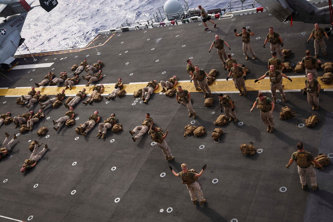 Marines with Golf Company, Battalion Landing Team 2nd Battalion, 1st Marines (BLT 2/1), 11th Marine Expeditionary Unit, conduct physical training on the flight deck of the USS Makin Island during the 11th MEU’s WESTPAC 14-2 deployment, Aug. 8, 2014. The 11th MEU and Makin Island Amphibious Ready Group are deployed as a sea-based, expeditionary crisis response force capable of conducting amphibious missions across the full range of military operations. (U.S. Marine Corps photo by Lance Cpl. Laura Y. Raga/Released)