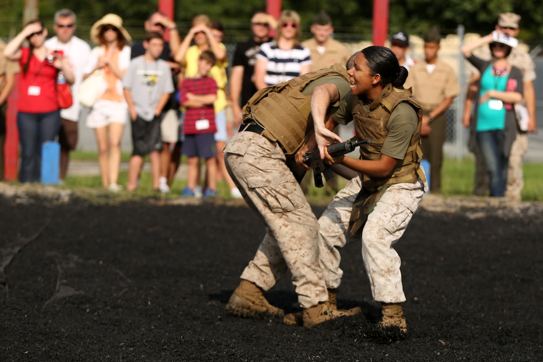 Family and friends look on as Sgt. Andrew T. Saffle and Cpl. Gina I. Jeffries perform self-defense moves during a demonstration of the Marine Corps Martial Arts Program at Marine Wing Communication Squadron’s family day Aug. 8, 2014.
MWCS-28 hosted their 3rd annual family day at Marine Corps Air Station Cherry Point, N.C., to help enhance unit operational readiness and to help family members better understand the contributions their Marine makes to the success of the squadron.
Saffle is a supply administration and operations specialist from Baltimore, Ohio, and Jeffries is an engineer equipment mechanic from Germantown, Md., both with MWCS-28. 
