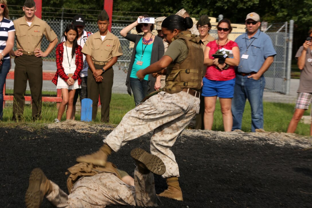 Family and friends look on as Sgt. Andrew T. Saffle and Cpl. Gina I. Jeffries perform self-defense moves during a demonstration of the Marine Corps Martial Arts Program at Marine Wing Communication Squadron’s family day Aug. 8, 2014.
MWCS-28 hosted their 3rd annual family day at Marine Corps Air Station Cherry Point, N.C., to help enhance unit operational readiness and to help family members better understand the contributions their Marine makes to the success of the squadron.
Saffle is a supply administration and operations specialist from Baltimore, Ohio, and Jeffries is an engineer equipment mechanic from Germantown, Md., both with MWCS-28.