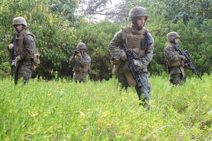 U.S. Marine Corps Lance Cpl. Mark Corpuz, second from left, documents other Marines assigned to the 3rd Battalion, 3rd Marine Regiment as they simulate patrol techniques on Marine Corps Base Hawaii in Hawaii March 24, 2010. Corpuz, who is a combat lithographer with Marine Forces Pacific, is conducting the photo shoot for Marine Corps Systems Command, which requested visual imagery showing the use of military-issued Canon camera gear in an operational environment. (DoD photo by Lance Cpl. Jody Lee Smith, U.S. Marine Corps/Released) 