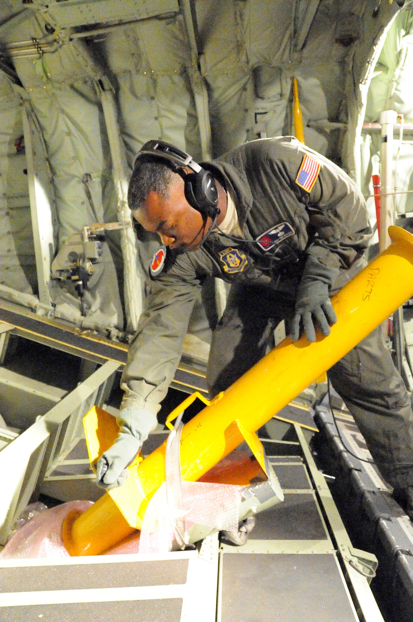 Master Sgt. Troy Bickham. 53rd Weather Reconnaissance Squadron loadmaster and dropsonde operator, pulls the handle on the launch adapter to release an ABXT buoy used by the U.S. Navy to collect salinity and water temperature during a flight through Hurricane Iselle off the coast of Hawaii Aug 7.   The 53rd WRS "Hurricane Hunters" aircrew and 403rd Wing maintenance personnel deployed to Hickham Air Force Base, Hawaii to fly storm missions into Hurricanes Iselle and Julio.  The "Hurricane Hunters" fly storm missions in both the Atlantic and Pacific Oceans during the hurricane season which offically starts June 1 and ends Nov. 30 yearly. (U.S. Air Force photo by Master Sgt. Jessica Kendziorek)  