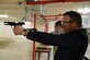 Under Secretary of the Air Force Eric Fanning fires a pistol at the combat arms training building during a base familiarization visit Aug. 5, 2014, on Spangdahlem Air Base, Germany. Fanning spoke with Airmen at locations across the base to hear how they directly contribute to operations and readiness. (U.S. Air Force photo/Senior Airman Gustavo Castillo)