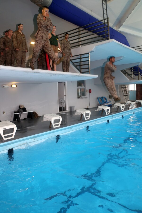Marines with Weapons Company, 1st Battalion, 24th Marine Regiment, jump off the high-dive during water survival qualification as part of their annual training during Exercise Heavy Metal 2014 at Marine Corps Base Camp Lejeune, North Carolina Aug. 11, 2014. After hitting the water, Marines must clear away simulated debris and successfully swim to safety until an instructor tells them to exit the pool. (U.S. Marine Corps photo by Cpl. J. Gage Karwick)