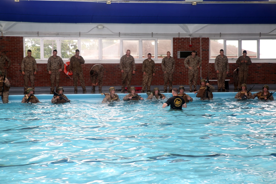A Marine Corps Instructor of Water Survival briefs Marines with Weapons Company, 1st Battalion, 24th Marine Regiment, on their next event during water survival qualification as part of their annual training during exercise Heavy Metal 2014 at Marine Corps Base Camp Lejeune, North Carolina Aug. 11, 2014. This portion of the course requires Marines enter the water wearing a vest, helmet and rifle and then submerge themselves and remove all the equipment in a set time limit.  (U.S. Marine Corps photo by Cpl. J. Gage Karwick)