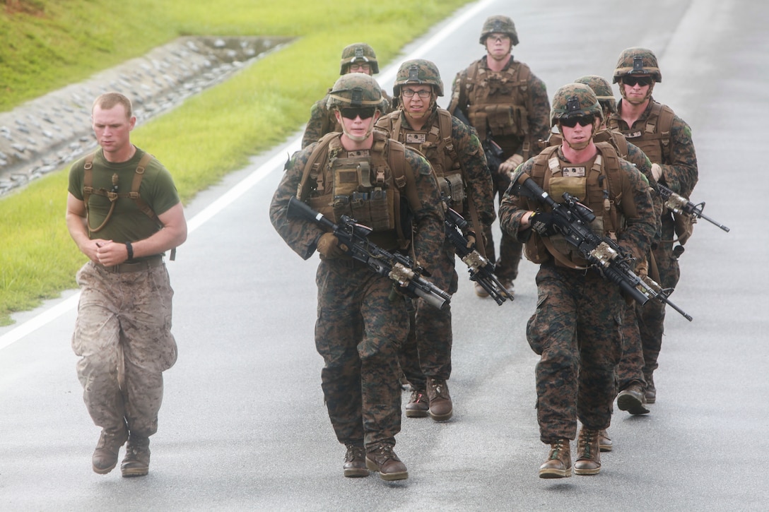 Marines with Company K, Battalion Landing Team 3rd Battalion, 5th Marines, 31st Marine Expeditionary Unit, run toward their next objective as part of a company squad competition at Camp Hansen, Aug. 8. The competition started at 5 a.m. with one squad starting every twenty minutes. There were seven total stations the BLT Marines had to complete, which included a physical circuit course where the Marines performed squad pushups, jumping lunges and air squats. Another station challenged the Marines to answer infantry-related questions for points that helped toward their overall time.  They concluded the competition with a swim before using their rifles to shoot at targets while moving from position to position.  The 31st MEU is the force of choice for the Asia-Pacific region and is the only continuously forward-deployed MEU. 
